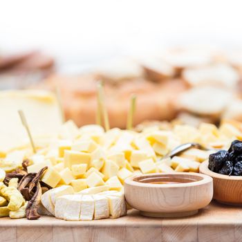 Cheese Plate with Dried Fruit and Honey. Rustic decoration on a wooden plate.