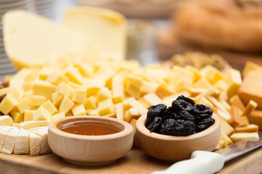 Cheese Plate with Dried Fruit and Honey. Rustic decoration on a wooden plate.