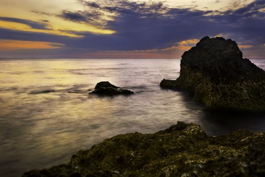 Fiery sunset, rock, and beach, Philippines