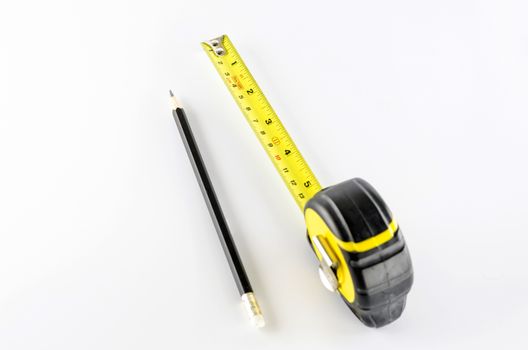 measuring tape with pencil on a white background