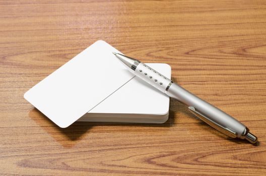 stack of business card with pen on wood background