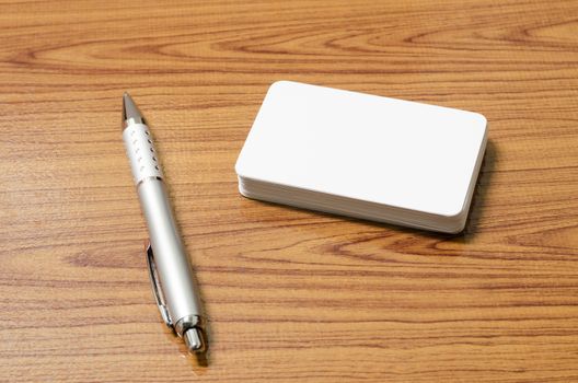 stack of business card with pen on wood background