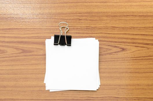 stack of paper with clip on wood background