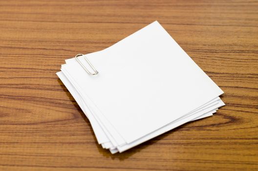 stack of paper with clip on wood background