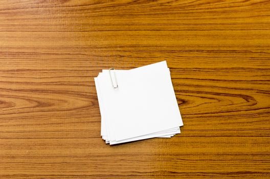 stack of paper with clip on wood background
