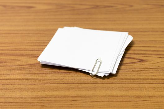 stack of paper with clip on wood background