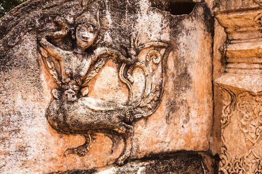 Ancient carving of kinnaree at the wall of lanna style temple in lampang, thailand