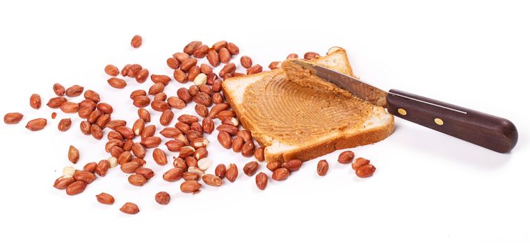 Peanut butter with heap of peanuts on the table