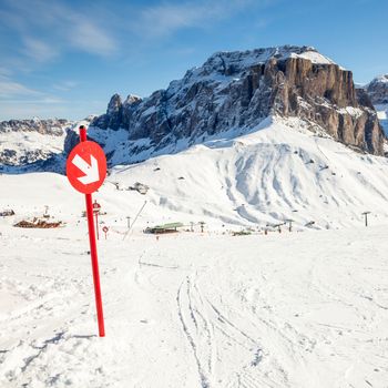 Red post sign marking the edge of ski slope