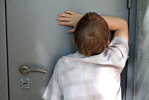 Sad Kid in front of Closed Door