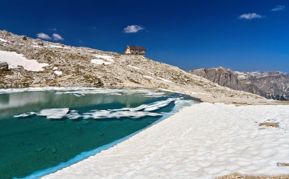 summer view of  Pisciadu lake with a small hut in Sella mountain, Alto Adige, Italy