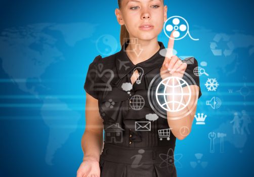 Beautiful businesswoman in dress finger presses virtual button. World map as backdrop