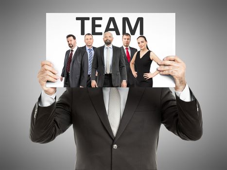 A business man holding a paper in front of his face with a team