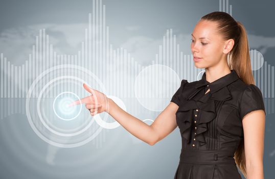 Beautiful businesswoman in dress finger presses virtual button. Graphs as backdrop