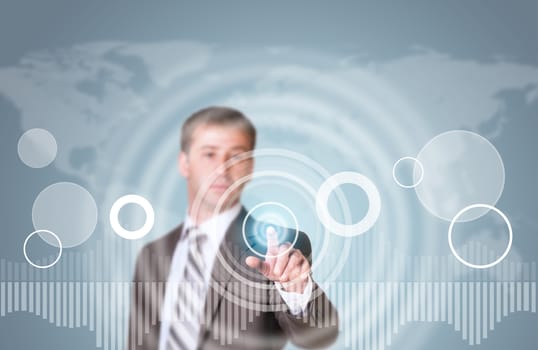 Businessman in suit finger presses virtual button. Graphs as backdrop