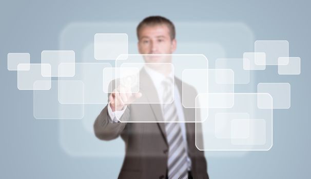 Businessman in suit finger presses virtual button. Blue business background