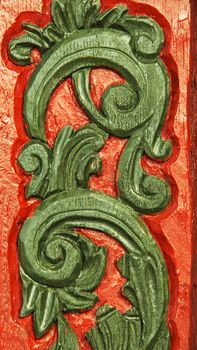 Detail of traditional Scandinavian woodcarving work in red and green. Vertical image