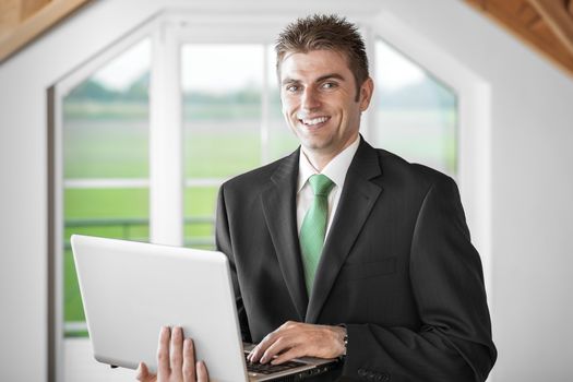 Image of a business man in dark suit with laptop