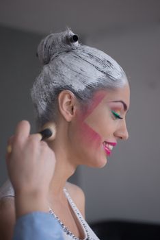 Smiling model during make up placement