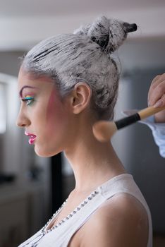 Make up artist applying magic at young girl model
