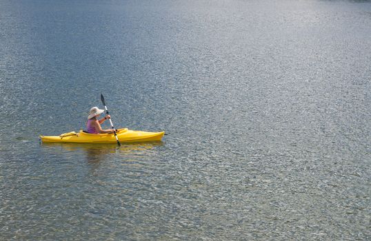 Woman Kayaking on Beautiful Peaceful Mountain Lake.