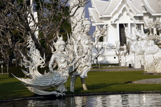 Modern Buddhist sculpture,.
White temple in Thailand.