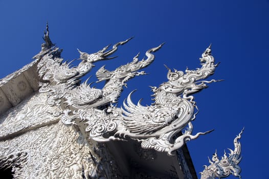 Modern Buddhist sculpture,.
White temple in Thailand.