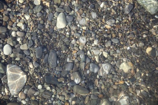 Gray pebble ground under the clear water