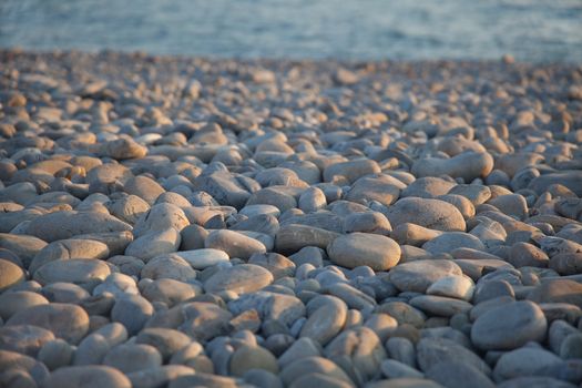 Shingle beach with blured sea at the sunset