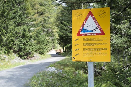 LA FOULY, SWITZERLAND - AUGUST 30: Flash flood warning sign on Mont Blanc tour path. The tour goes through three countries and is clearly signalised throughout. August 30, 2014 in La Fouly.