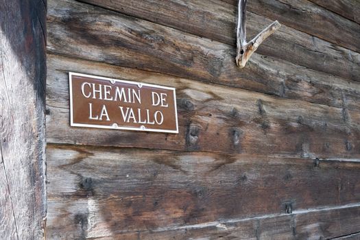 PRAZ-DE-FORT, SWITZERLAND - AUGUST 30: Vallo Way sign on wooden wall. The village is a stage of Mont Blanc tour, which goes through three countries. August 30, 2014 in Praz-de-Fort.
