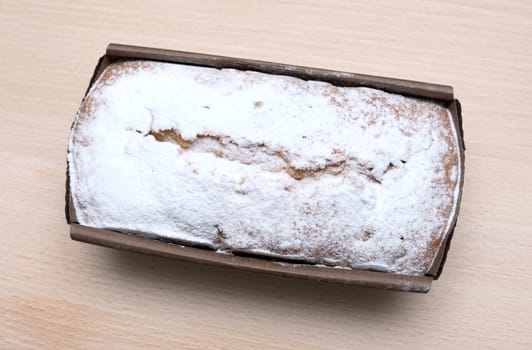 Ruddy rectangular cake on a wooden board