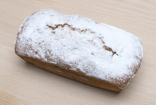 Ruddy rectangular cake on a wooden board