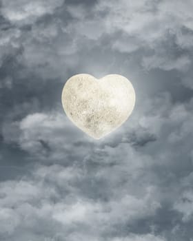 shining moon in shape of heart on the night  sky among the clouds