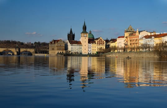 Photo shows various historical houses, Vltava river, bridges and other architectural details.