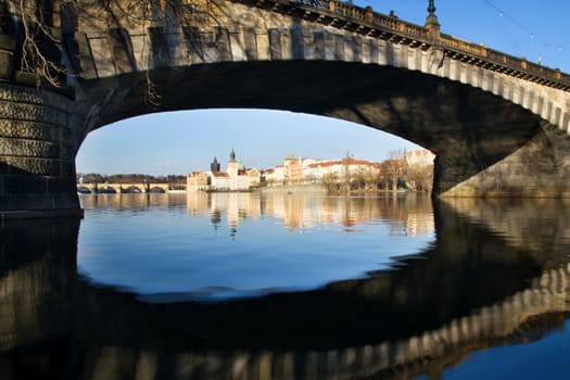 Photo shows various historical houses, Vltava river, bridges and other architectural details.