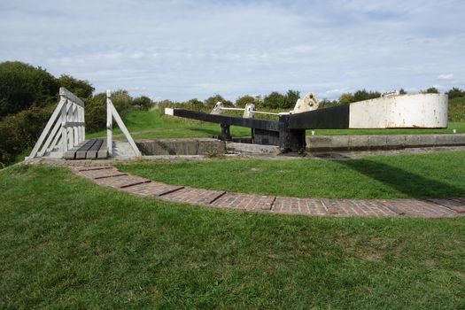 One of the twenty-nine Caen Hill Locks, showing the white wooden footbridge and balance beams