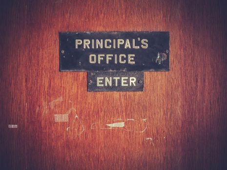Retro Filtered Image Of A Grungy Principal's Office Door At A Public School In The USA