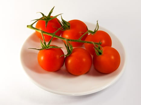 Photo presents details of red tomatoes on the white background.