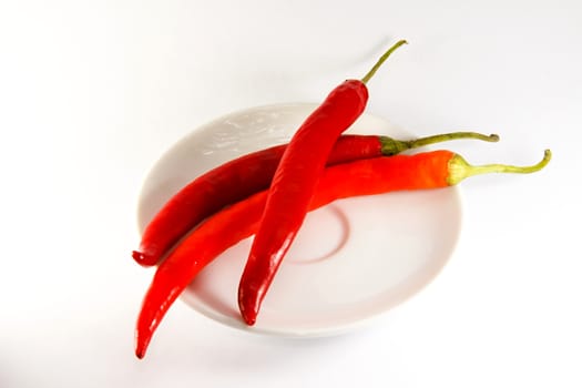 Photo presents details of red peppers on the white background.