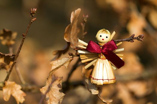 Photo shows a straw angel figurine in the wood.