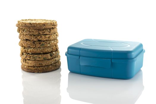 blue lunchbox and stack of rusks isolated on white