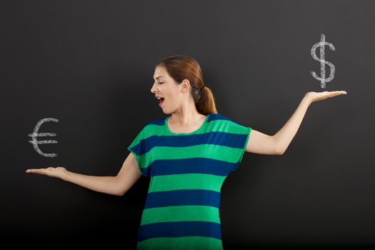 Happy woman in front of a chalkboard ilustrating a concept about money currency 