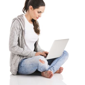 Beautiful woman sitting in the floor and working with a laptop