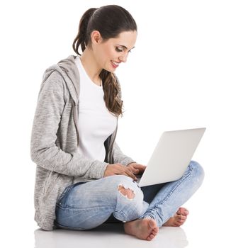 Beautiful woman sitting in the floor and working with a laptop