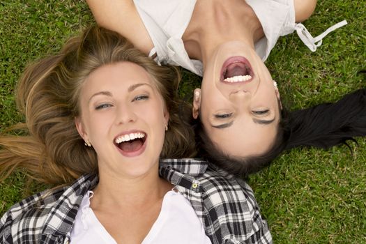 Female best Friends lying on the grass and laughing