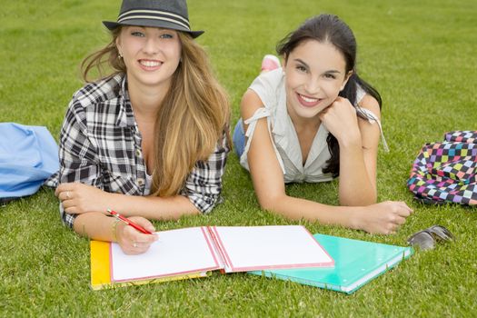 Tennage students lying on the grass and study together