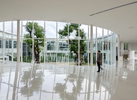 Glass wall in the modern building with people walking in motion blur 