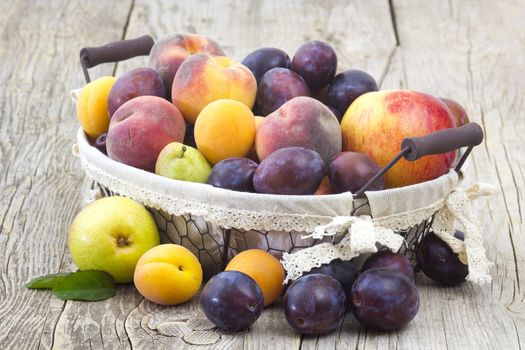 fresh fruits in a basket on wooden background