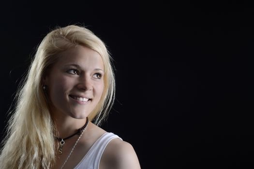 beautiful young blond woman against black background